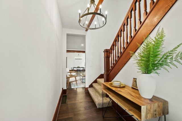 foyer entrance featuring a chandelier, stairs, baseboards, and wood finished floors