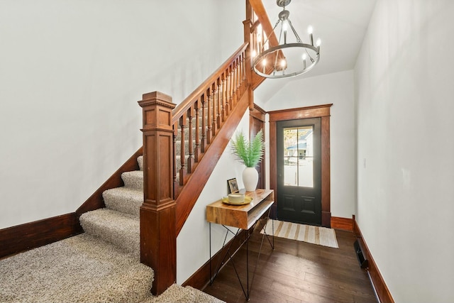 entrance foyer featuring baseboards, stairs, an inviting chandelier, and wood finished floors