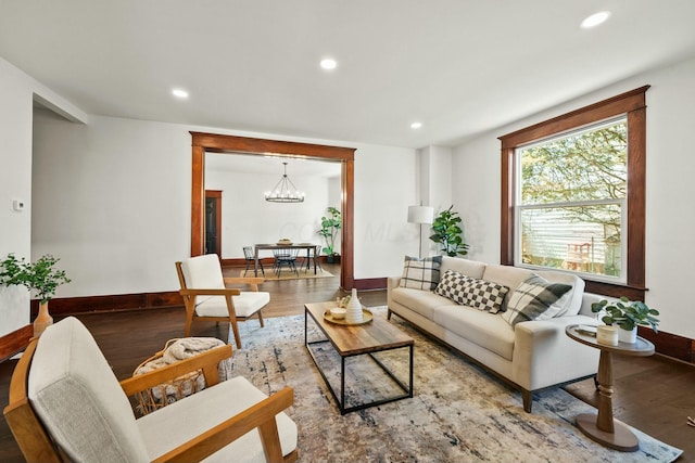 living room featuring a chandelier, recessed lighting, baseboards, and wood finished floors