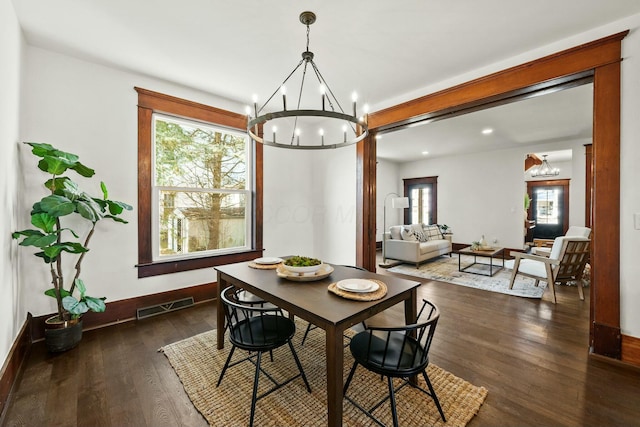 dining space featuring visible vents, a notable chandelier, and dark wood-style flooring