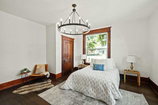 bedroom with baseboards, dark wood-style flooring, and a chandelier