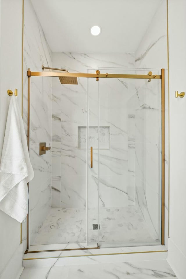 bathroom featuring marble finish floor and a marble finish shower