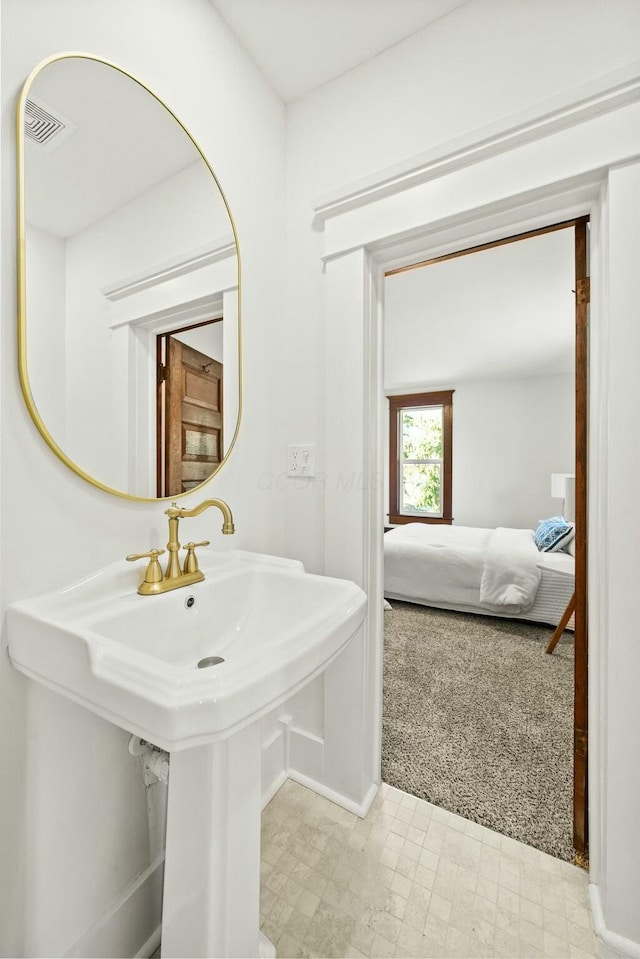 ensuite bathroom with tile patterned floors, visible vents, ensuite bathroom, and a sink