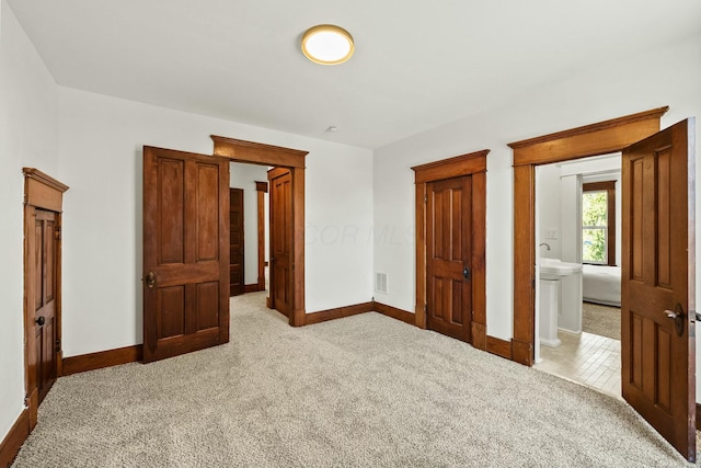 unfurnished bedroom with visible vents, light colored carpet, and baseboards