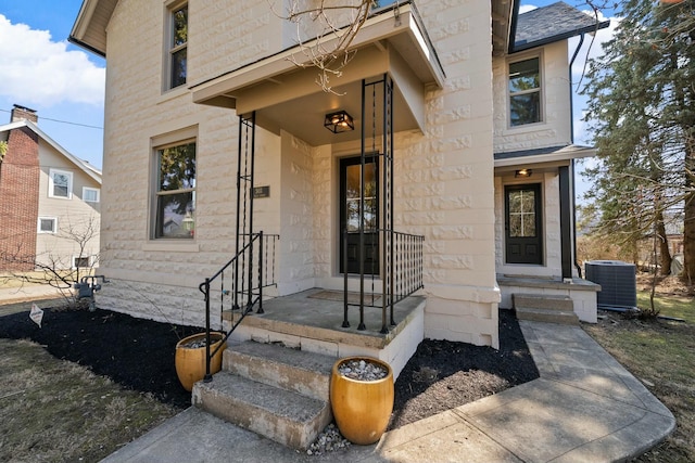 entrance to property featuring stone siding and central AC