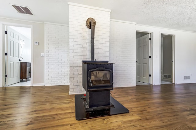 details with visible vents, a wood stove, and wood finished floors