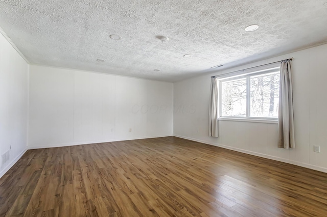 empty room featuring a textured ceiling and wood finished floors