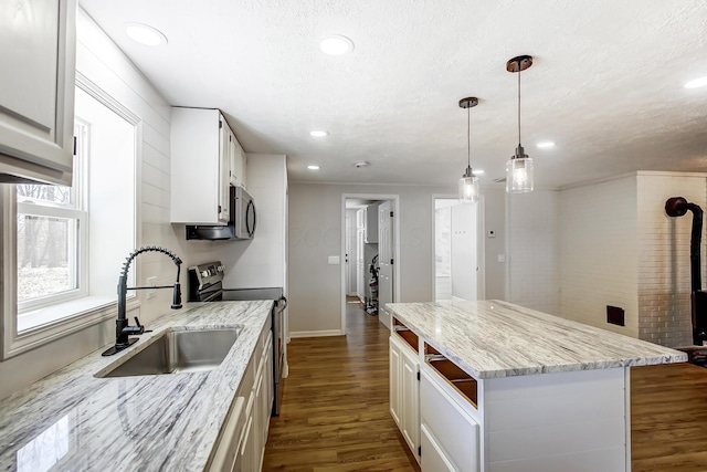 kitchen featuring dark wood-style floors, appliances with stainless steel finishes, white cabinetry, and a sink