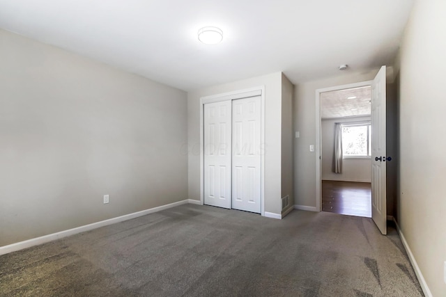 unfurnished bedroom with visible vents, baseboards, a closet, and carpet floors