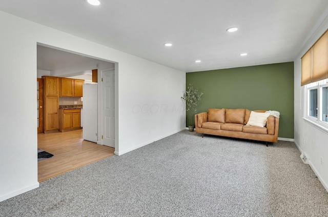 living area with visible vents, recessed lighting, baseboards, and light carpet