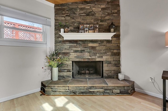 room details featuring a fireplace, baseboards, and wood finished floors