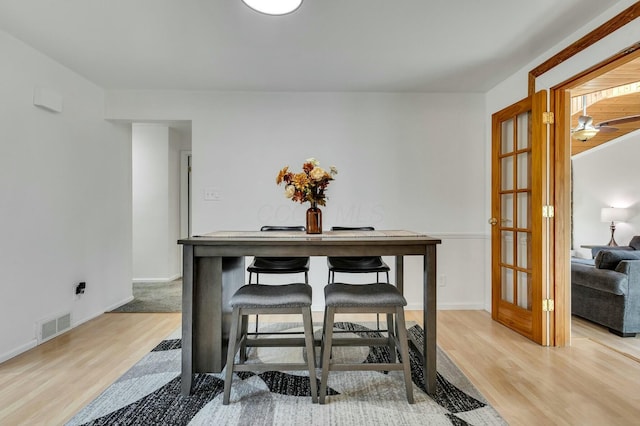 dining room featuring baseboards, visible vents, and light wood finished floors