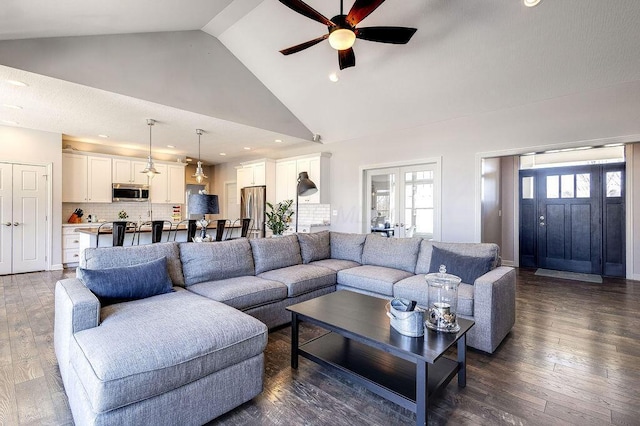 living area with french doors, plenty of natural light, high vaulted ceiling, and dark wood finished floors