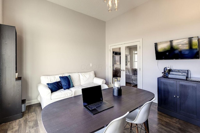 dining space with french doors, lofted ceiling, baseboards, and wood finished floors