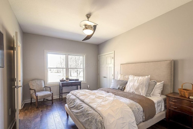 bedroom with ceiling fan, baseboards, and dark wood-style flooring