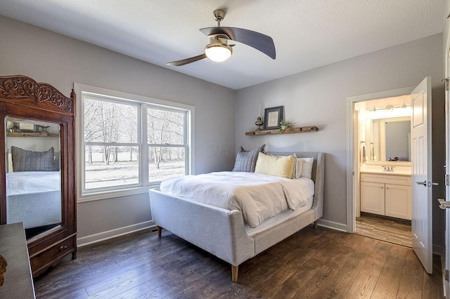 bedroom featuring dark wood-style floors, ceiling fan, baseboards, and a sink