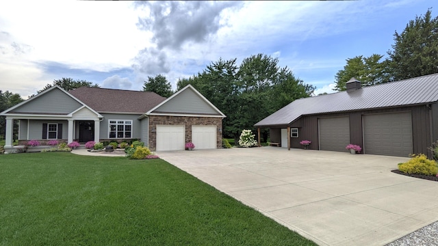 view of front facade with a garage, a chimney, metal roof, and a front yard