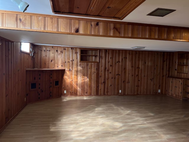 basement featuring wood finished floors and wood walls