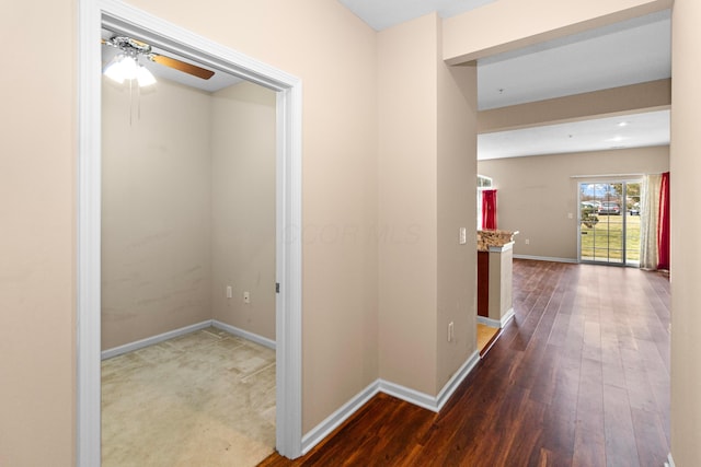 hallway with baseboards and wood finished floors