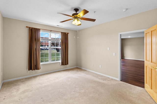 spare room with baseboards, carpet flooring, a ceiling fan, and visible vents