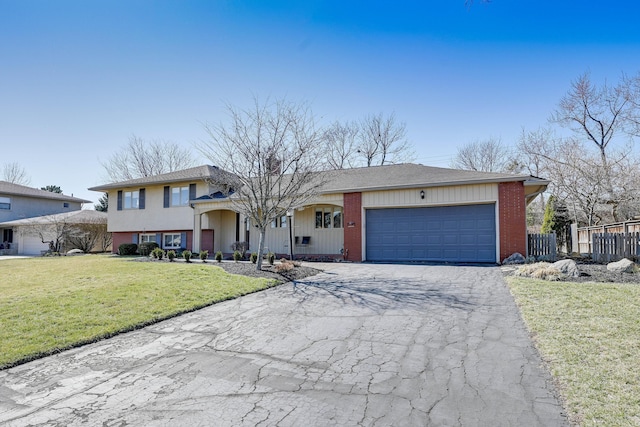 split level home with driveway, fence, an attached garage, a front yard, and a chimney