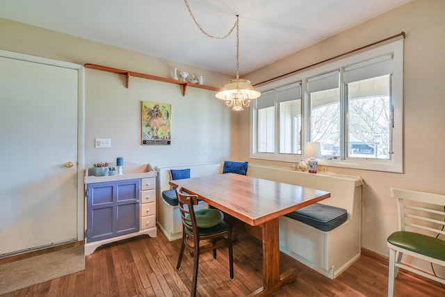 dining space featuring breakfast area, baseboards, an inviting chandelier, and dark wood-style flooring