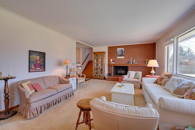 living area with stairway, carpet, a brick fireplace, and ornamental molding