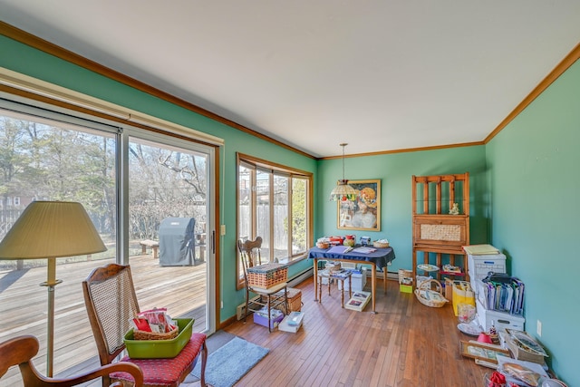 rec room with baseboards, ornamental molding, and hardwood / wood-style flooring