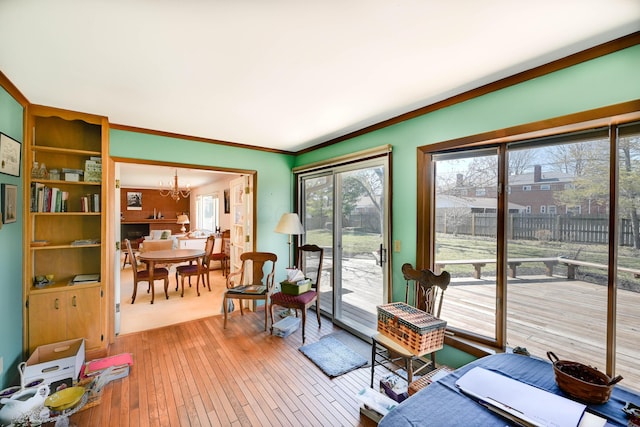 interior space with crown molding, a notable chandelier, and light wood-style floors