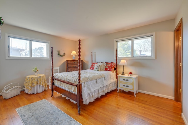 bedroom featuring light wood finished floors and baseboards