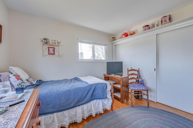 bedroom with wood finished floors and a closet