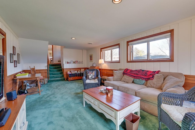 carpeted living area featuring recessed lighting, stairs, and a decorative wall