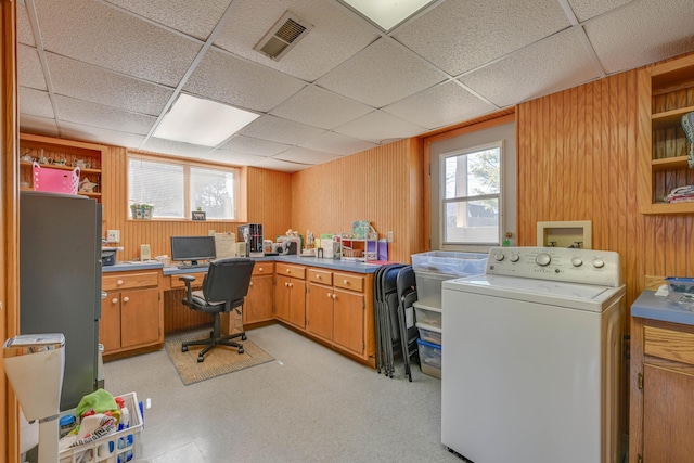 office area with washer / dryer, wooden walls, a paneled ceiling, and visible vents