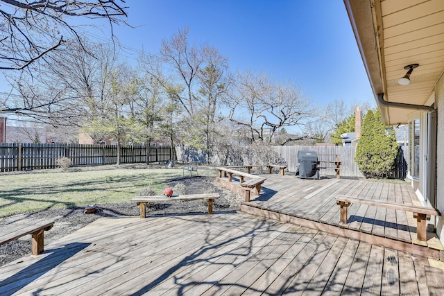 wooden terrace featuring a grill and a fenced backyard