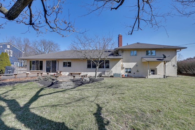 rear view of property featuring central AC, a lawn, stucco siding, a chimney, and a patio