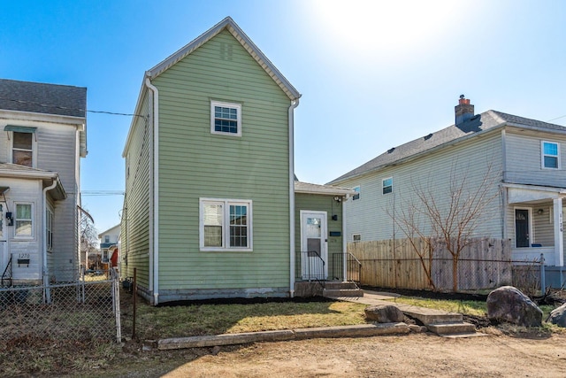 rear view of house featuring fence