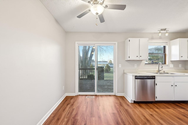 kitchen with wood finished floors, visible vents, white cabinetry, a sink, and dishwasher