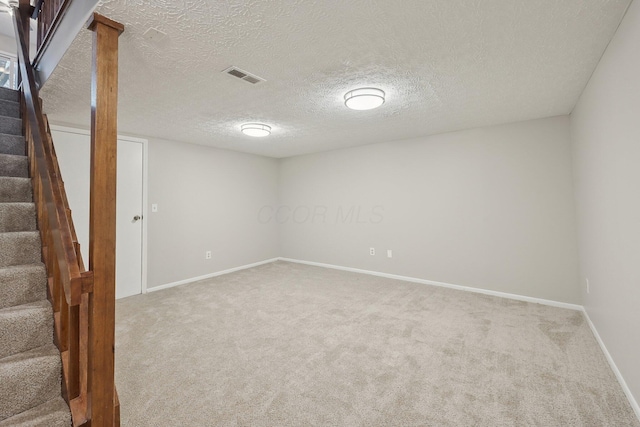 finished basement with visible vents, baseboards, carpet, and stairs