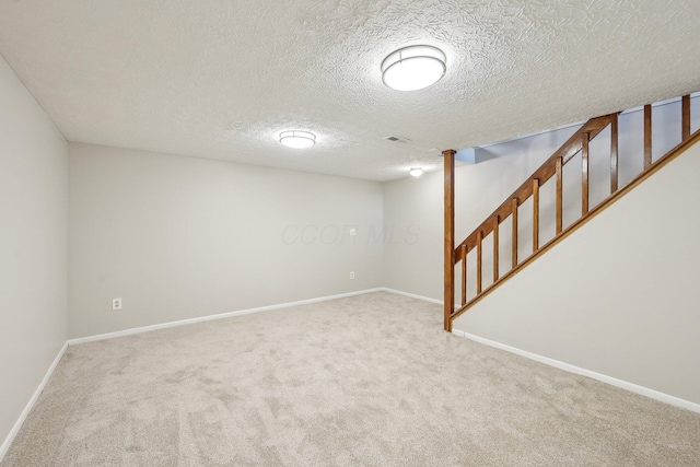 finished below grade area with stairway, baseboards, visible vents, and carpet floors