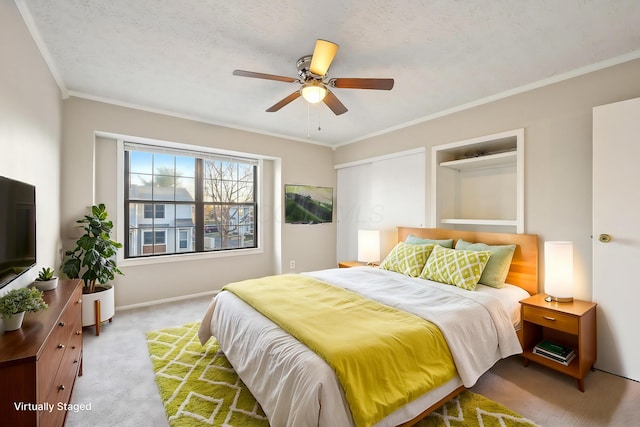 carpeted bedroom with ceiling fan, baseboards, and ornamental molding