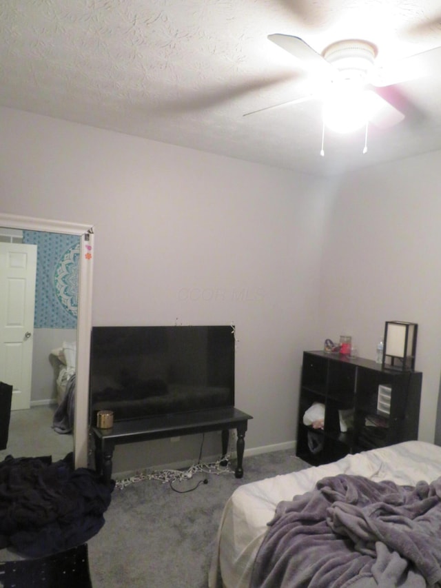 carpeted bedroom with a ceiling fan and a textured ceiling