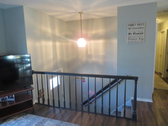 staircase with baseboards and wood finished floors