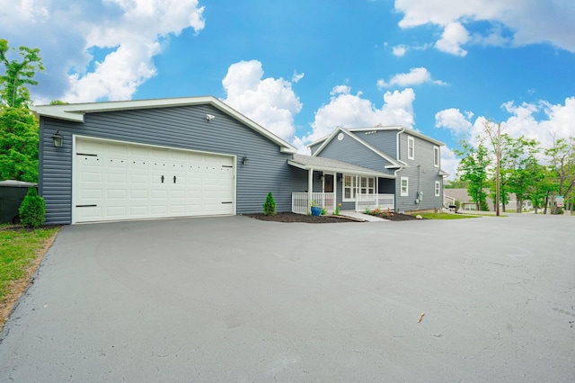 view of front of house with covered porch, driveway, and a garage