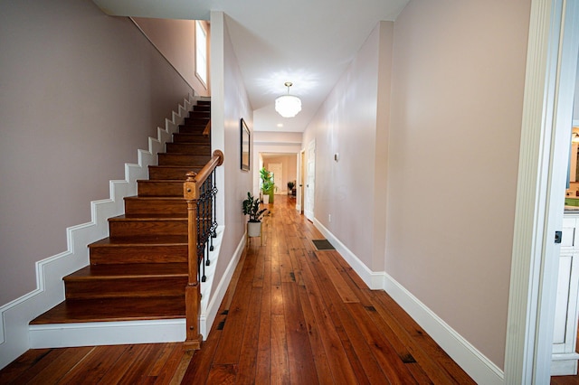 corridor featuring stairs, visible vents, baseboards, and wood-type flooring