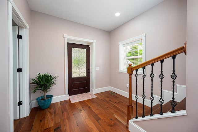 foyer featuring visible vents, baseboards, stairs, recessed lighting, and hardwood / wood-style flooring