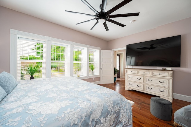 bedroom with a ceiling fan, baseboards, and dark wood-style flooring