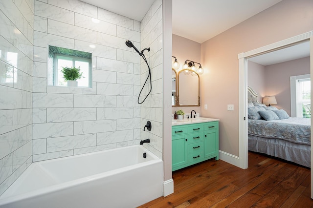 bathroom with ensuite bathroom, hardwood / wood-style flooring, shower / bathing tub combination, baseboards, and vanity