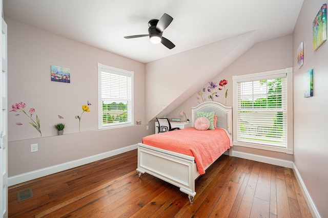 bedroom featuring a ceiling fan, visible vents, baseboards, vaulted ceiling, and wood-type flooring