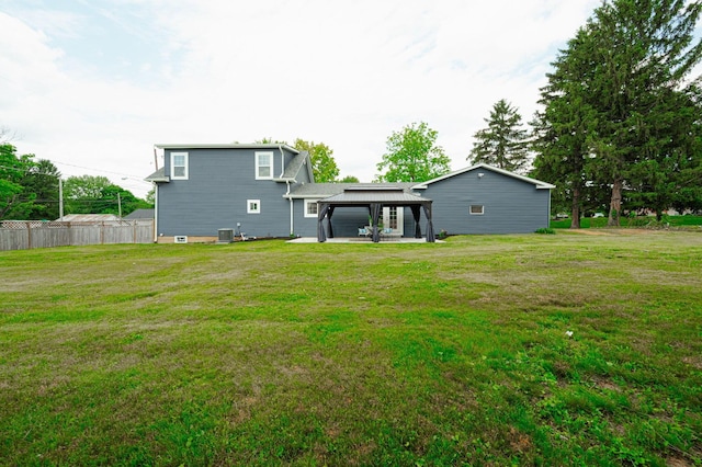 rear view of property with a gazebo, a patio, a lawn, and fence