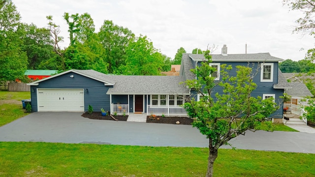 view of front of house featuring a front lawn, an attached garage, covered porch, and driveway